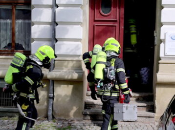Feuerwehr rückt wegen Küchenbrand in Chemnitz aus - Mit Atemschutzausrüstung betreten Einsatzkräfte das Haus.