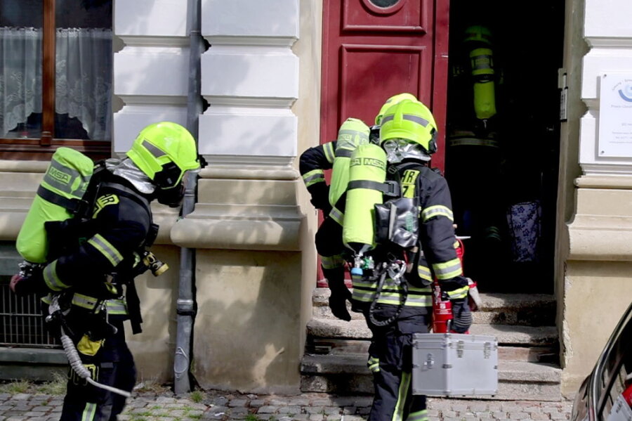 Feuerwehr rückt wegen Küchenbrand in Chemnitz aus - Mit Atemschutzausrüstung betreten Einsatzkräfte das Haus.