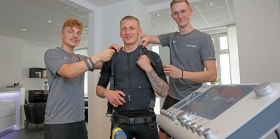 Fitnessstudio-Eröffnung trotz Pandemie - André Herold (l.) und Likas Dörken (r.) rüsten Marc-Philipp Zimmermann mit der EMS-Technik aus. 