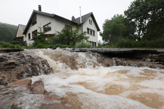 Wasser läuft bei Heimbach an einem Haus vorbei den Hang hinunter