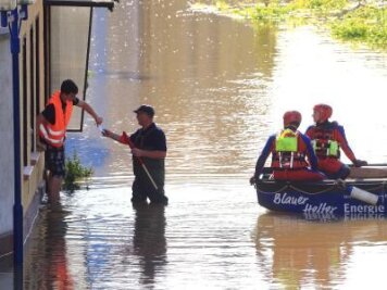 Flutwelle rollt gen Norden - Rettungskräfte reden in Sachsen-Anhalt mit einem Bewohner eines überschwemmten Hauses.