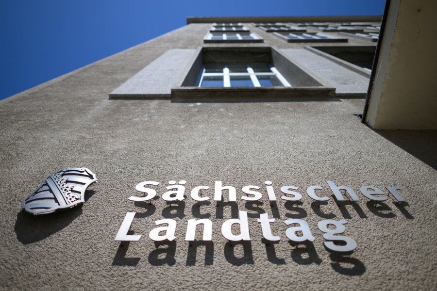 Foren sollen Bürgern Wahlentscheidung erleichtern - Sächsischer Landtag und eine Wappen von Sachsen sind an der Fassade am Altbau des Parlamentsgebäudes montiert.