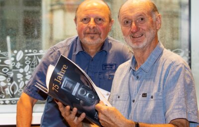 Fotoclub feiert 75-Jähriges - Clubchef Jürgen Zorn (rechts) und sein Vize Bernd Hegner blättern in der druckfrischen Broschüre, die sich der Fotoclub Vogtland zu seinem Jubiläum gegönnt hat. 