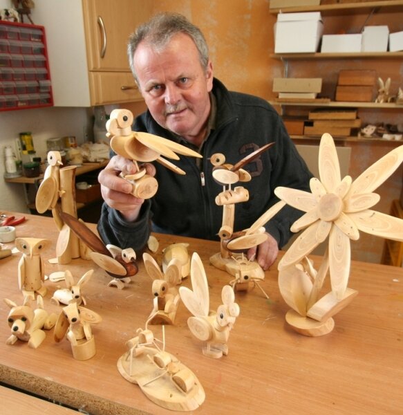 Mann mit Holzfiguren