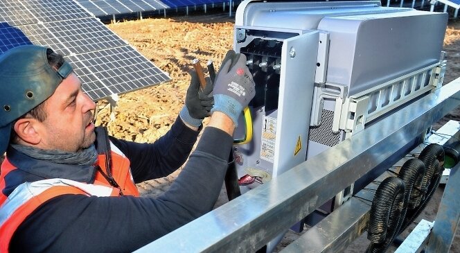 Frankenberg setzt auf die Sonne - Ingo Daniel von der Firma Schoenergie verkabelt im bereits bestehenden Solarpark in Dittersbach einen Wechselrichter. 