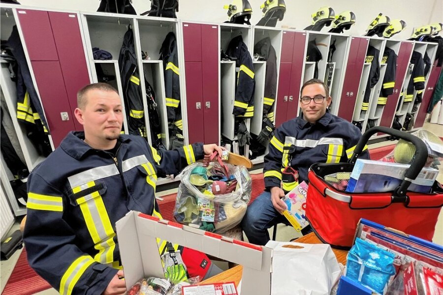 Frankenberger erzählt, warum Feuerwehr cool ist - Die Kameraden René Lüth (links) und Marco Vogel bereiten die Geschenke für den Nikolausexpress der Freiwilligen Feuerwehr Dittersbach vor.