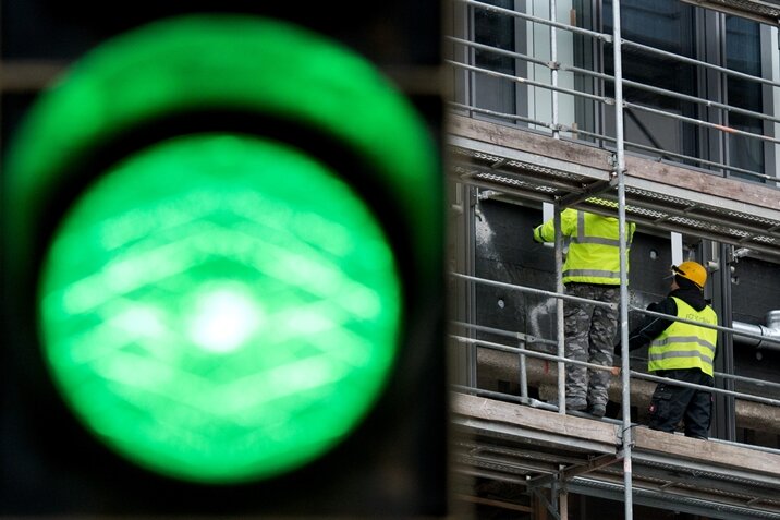 Frau übersprüht Lichtzeichen von Baustellenampel - 