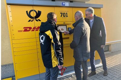Fraureuth: Gemeinde nimmt erste Poststation in Betrieb - Bürgermeister Matthias Topitsch (Mitte) lässt sich den neuen Automaten von den Postmitarbeitern erklären.