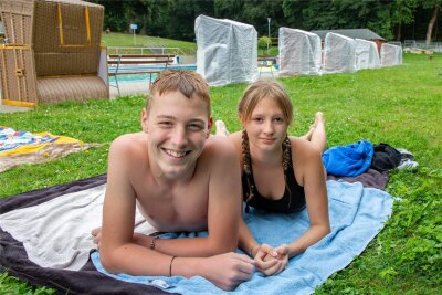 Freibadsaison an der gesperrten B 173 bei Flöha: „Wir hatten halb so viele Badegäste wie sonst.“ - Bei fast jedem Wetter zieht es Emily und Julian ins Freibad Falkenau. Selbst einige Regentropfen vertreiben die jungen Leute nicht.