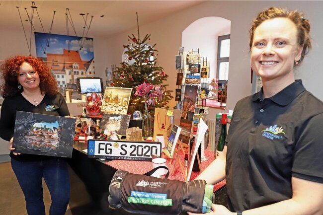 Carolin Zimmermann (l.) und Babett Erler mit Freiberg-Geschenken in der Tourist-Information.