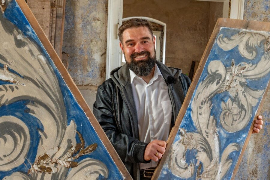 "Freie Presse"-Entdeckertour: Das Haus des Montanunternehmers in Carlsfeld - Der Geschichtsverein Carlsfeld heißt im Hammerherrenhaus des Ortes (Foto rechts unten) willkommen. Dort sind unter anderem die einzigartige, mit Kobaltblau bemalte Holzbalkendecke, die Vereinsvorsitzender Mirko Sauerbaum hält (oben), und Elemente aus der Zeit seines Baus um 1680 zu entdecken. In der Trinitatiskirche gibt es ein Benefizkonzert mit dem Bandonionorchester, in dem auch Demian Wallschläger (Foto links unten) spielt.