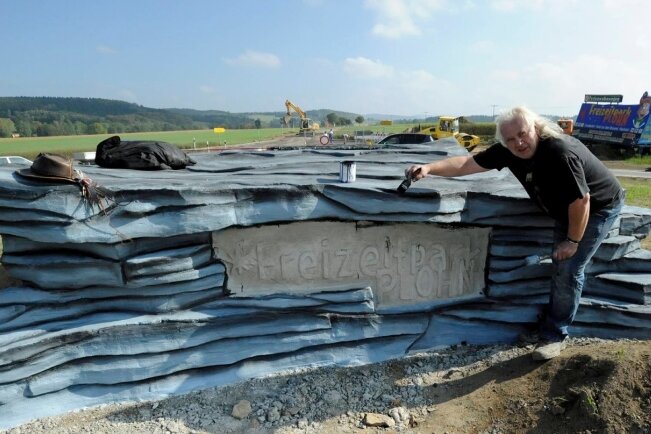 <p class="artikelinhalt">Jens Weber beim Bemalen des künstlichen Felsens auf der Mittelinsel des neuen Kreisverkehrs. </p>