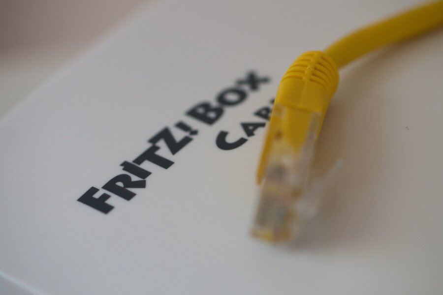 Fritz!-Box-Hersteller AVM muss saftige Geldbuße zahlen - Ein Netzwerkkabel liegt auf einem Fritz!-Box-Router der Firma AVM.