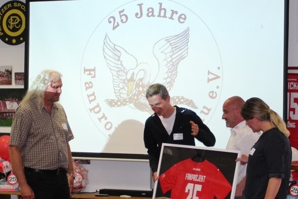 Vorsitzender Thomas Richter (li.) erhielt das Jubiläumstrikot von den Fanbeauftragten Riccarda Schröter (re.) und Christian Würtemberger (2. v. li.) sowie Jörg Schade, Bereichsleiter Sport des FSV Zwickau.