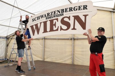 Für die Schwarzenberger Wiesn ist alles gerichtet - Patrick Weigel, Christoph Braune und Enrico Huttrich (v. l.) sorgen für die Deko im Partyzelt auf dem Festplatz.