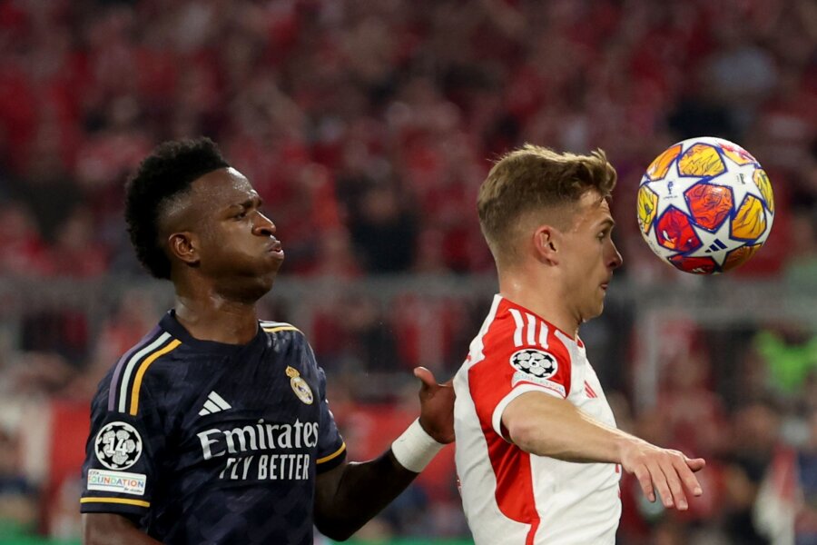 Fußball-Drama in München: Später Elfmeter schockt Bayern - Joshua Kimmich (r) behauptet den Ball gegen Vinicius Junior.