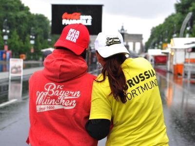 Fußball-Feste in Dortmund und München, wenig Zuschauer in Berlin - Zwei Frauen in Fankleidung auf der verregneten Fanmeile in Berlin.