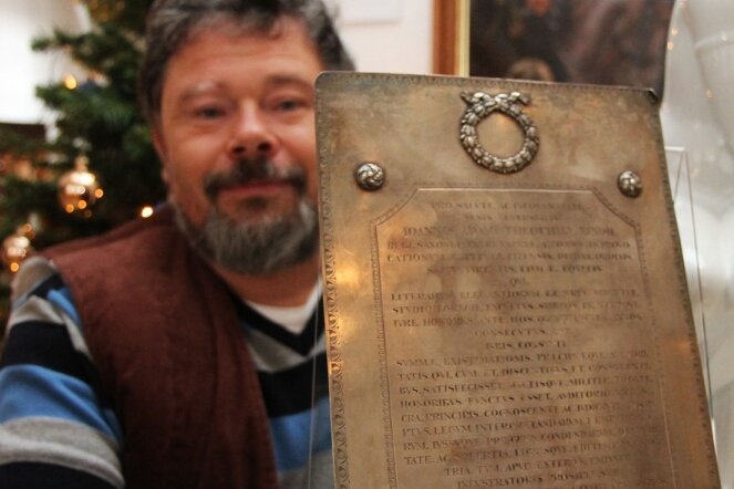 Gabentisch für Museum gedeckt - Hans-Jürgen Beier zeigt die Ehrenplakette aus Silber, die das Leben und Schaffen Christoph Kinds würdigt. Die Tafel wiegt zirka ein Kilogramm.