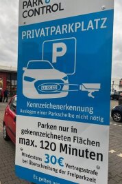 Ganz ohne Parkscheibe: Auf einem Werdauer Parkplatz wird mit Kennzeichenerkennung kontrolliert - Mit dem Schild wird über die Überwachung des Parkplatzes informiert.