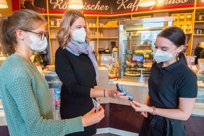 Gastwirt aus Neukirchen: Unter 2G plus lohnt längeres Öffnen nicht - Jennifer Lubojanski, Mitarbeiterin im "Café am Stern", kontrolliert die 2G-plus-Nachweise von Juliane (links) und Daniela Drews. 