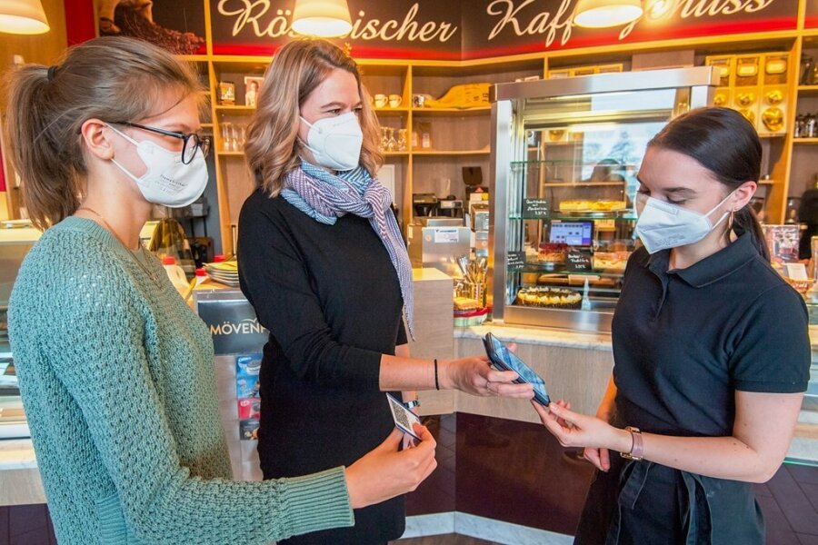 Jennifer Lubojanski, Mitarbeiterin im "Café am Stern", kontrolliert die 2G-plus-Nachweise von Juliane (links) und Daniela Drews. 