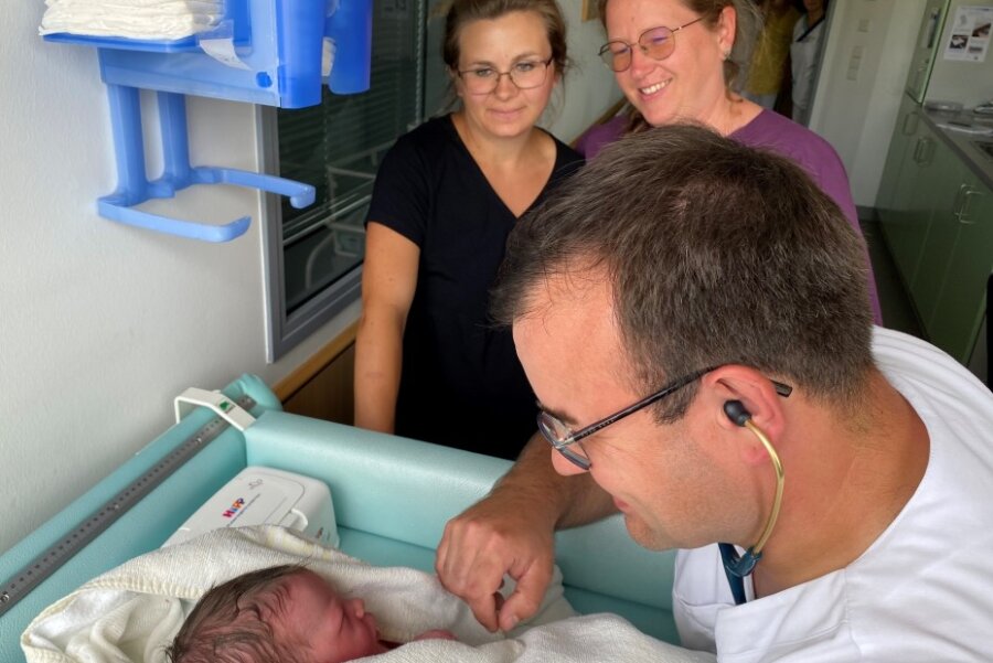 Der Chefarzt der Kinder- und Jugendmedizin im Krankenhaus Mittweida, Norman Händel, untersucht ein neugeborenes Baby. Die leitende Hebamme Peggy Kruggel (hinten rechts) freut sich, dass es dem Kind und Mutter Stefanie Lein gut geht.
