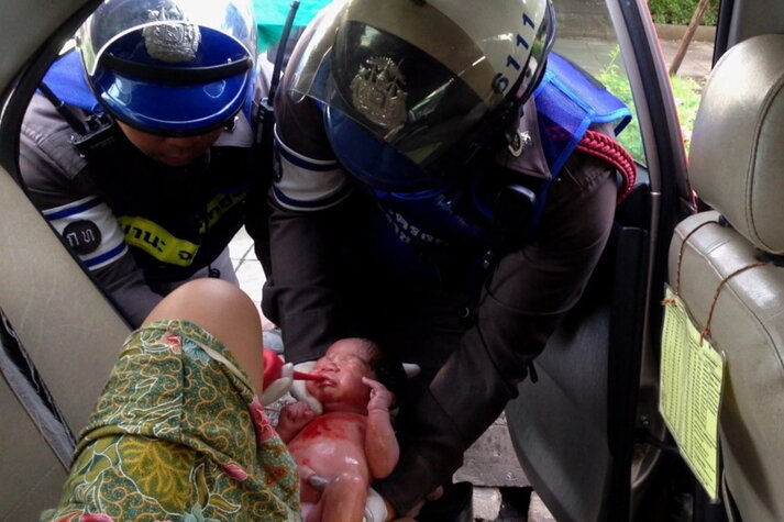 Das Bild der Polizei Bangkok vom Juni zeigt einen speziell geschulten Polizisten, der bei der Geburt eines Babys in einem Taxi in Thailand hilft. Die andauernden Staus in Thailands Hauptstadt bescheren manchen schwangeren Frauen eine Geburt im Auto auf dem Weg ins Krankenhaus. Eine speziell geschulte Polizeieinheit hat bereits mehr als 100 Babys am Straßenrand zur Welt gebracht. 