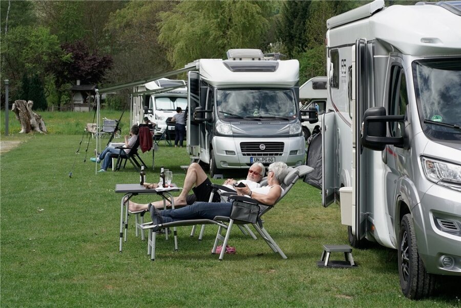 Camper liegen vor ihrem Wohnmobil in der Sonne. Die Gefährte sind vor allem in Norddeutschland beliebt, im Osten weniger. Die Chemnitzer Zulassungsquote liegt noch unter dem sächsischen Durchschnitt.