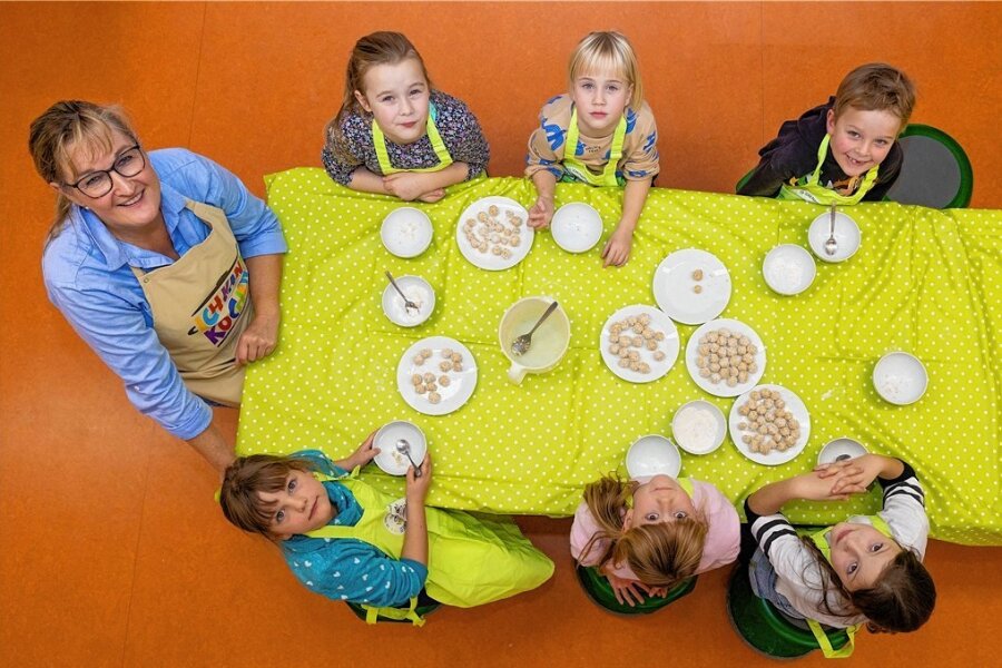 Gemeinsam kochen gegen Übergewicht - Sie können kochen! Und Sahne-Hafer-Kugeln machen: Marianne Hutt-Flum zeigt den Mädchen und dem Jungen ihres Koch-und Backkurses in einer Grundschule in Dresden, wie es geht. 