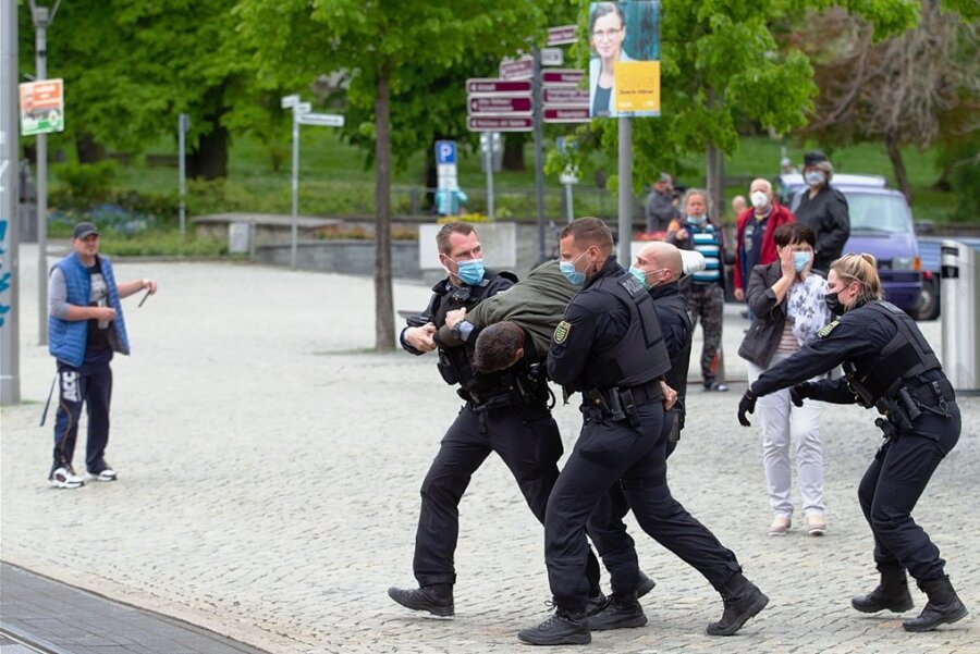 Ende Mai 2021 am Rande einer Wahlkampfveranstaltung: Polizeibeamte tragen einen Mann zu einem Einsatzfahrzeug, um die Personalien aufzunehmen. 