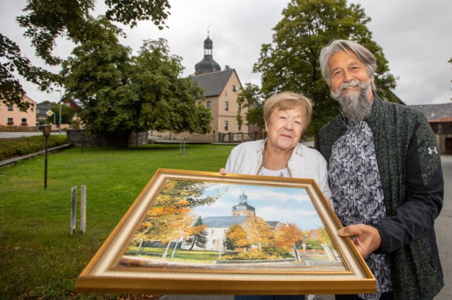Christina Schneider übergibt das Gemälde ihres verstorbenen Mannes als Geschenk an die Gemeinde. Bürgermeister Ulrich Sörgel nimmt es dankbar entgegen und verspricht, dass es einen Ehrenplatz erhält. 