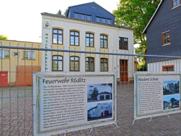 Geschichtsquiz führt Teilnehmer durch Rödlitz - Vor vielen Rödlitzer Gebäuden, wie hier der Feuerwache und der früheren Niederen Schule, wurden Plakate mit Informationen zu deren Geschichte angebracht.