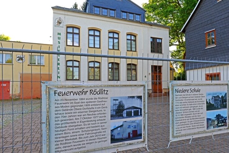 Vor vielen Rödlitzer Gebäuden, wie hier der Feuerwache und der früheren Niederen Schule, wurden Plakate mit Informationen zu deren Geschichte angebracht.