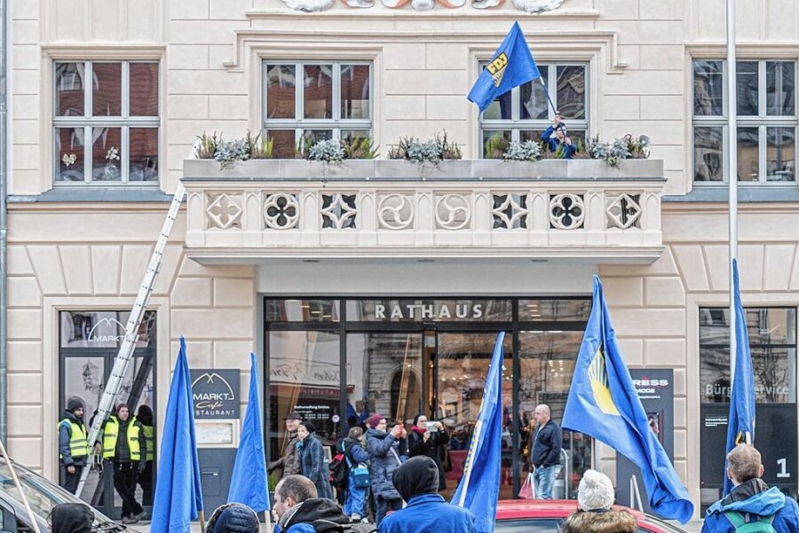 Gestürmter Rathausbalkon: Zwickauer Gericht stellt Prozess gegen FDJ-Aktivisten ein - März 2020: FDJ-Demonstranten klettern auf den Rathausbalkon und schwenken die blaue Fahne. 