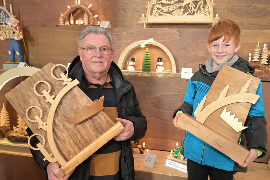 Gewinner des Schwibbogen-Wettbewerbs in Stollberg: Großvater und Enkel werden „König“ und „Prinz“ - Rolf Aurich (73) und Tyler (9) halten nach der Siegerehrung die Wanderpokale in den Händen.