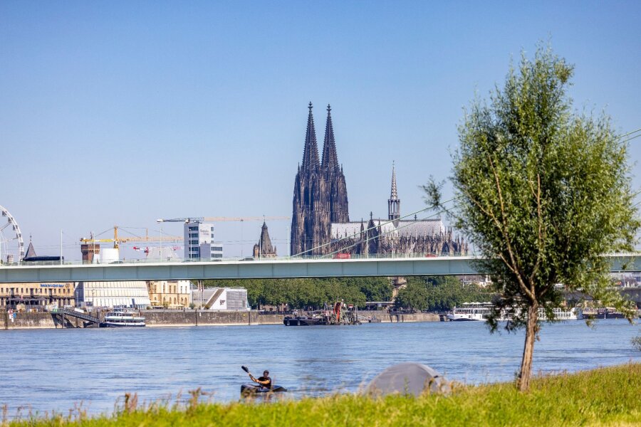 Gewitterrisiko steigt - Wetterwechsel am Freitag - Ein Kajakfahrer rudert auf dem Rhein, im Hintergrund ist der Kölner Dom und die Severinbrücke zu sehen.