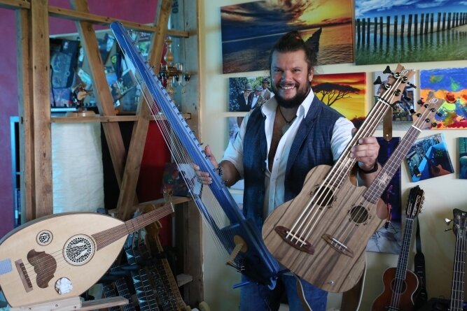 Gitarrist will ein für ihn neues Instrument präsentieren - Vicente Patíz mit seinen neuen Instrumenten. Die Hydra (rechts) ist Ukulele und Kontrabass in einem. 