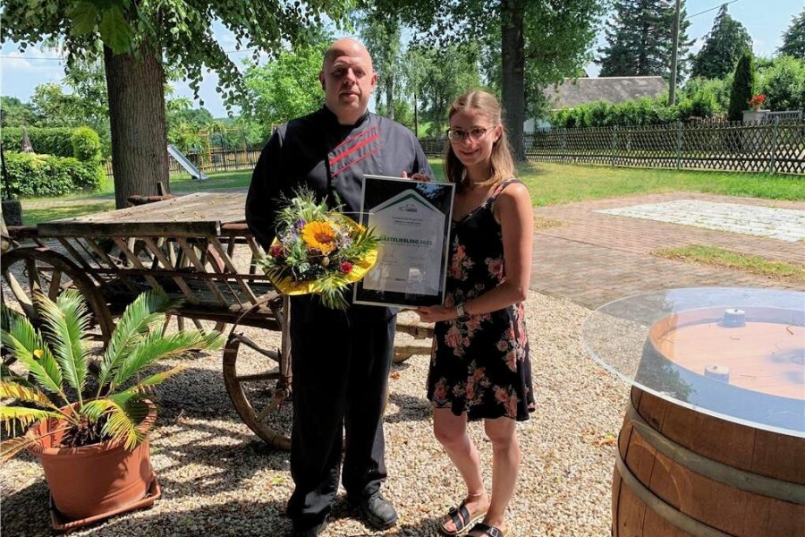 Glauchauer Landgasthof ist „Gästeliebling“ - Julia Keller von der Tourismusregion übergibt Gasthofchef Marcel Piegholdt die Auszeichnung.