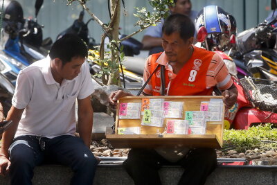 Glück mit Sarg Nummer 391: Thailänder feiern Lottogewinn - Ein Lotto-Verkäufer in Bangkok (Symbolfoto).