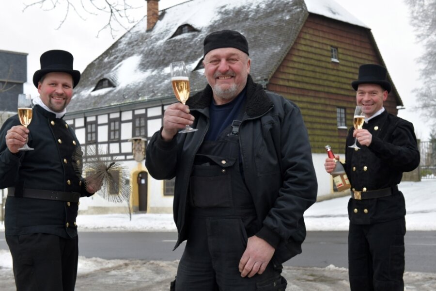 Glücksbringer gibt Kehrbesen weiter - Schornsteinfegermeister Uto Berger (mitte) übergibt sein Amt an Nachfolger Marek Lorenz (links). Mirko Beer (rechts) feiert mit beiden.