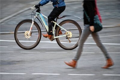 GPS-Tracker weist auf E-Bike-Dieb hin - Ein E-Bike-Fahrer und eine Fußgängerin sind im Stadtverkehr unterwegs (Symbolbild). Foto: Sebastian Gollnow/dpa/Archiv