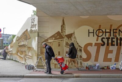 Graffiti-Künstler machen Brücke in Hohenstein-Ernstthal zum Kunstwerk - Das Hohenstein-Ernstthaler Rathaus gehört zu den lokalen Motiven, mit denen die Sprayer der Fassadengestaltung Dresden die Bahnbrücke an der Lungwitzer Straße gestaltet haben.
