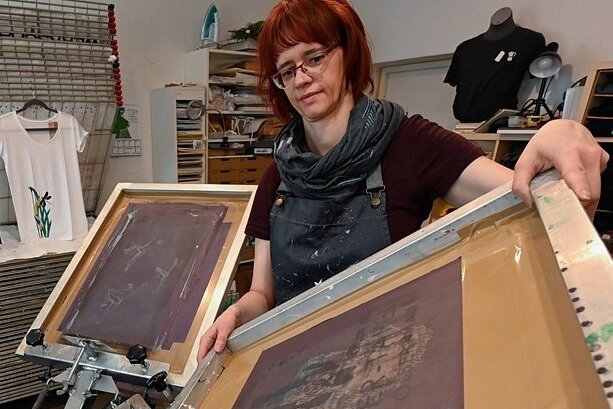 Grafikerin macht Druck - gegen die Krise und mit Fantasie - Grafikerin Peggy Albrecht bei der Einrichtung des Siebdruck-Karussells für das Bedrucken von Textilien. 
