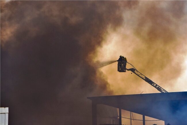 Großbrand bei Müllfirma im Vogtland - Warnung aufgehoben - Harte Arbeit an der Quelle der riesigen, über die Region wehenden Rauchfahne. Über in die Wand der Halle gerissene Löcher gelang es der Feuerwehr schließlich von zwei Drehleitern aus, das Feuer einzudämmen und zu löschen. 