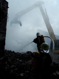 Großbrand bei Pyral in Mittweida: Löscharbeiten dauern an - Feuerwehrkräfte am Sonntagnachmittag beim Löscheinsatz in der vom Brand betroffenen Halle. 
