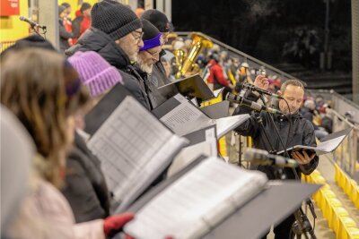 Großes Weihnachtssingen im Auerbacher Stadion besteht Premiere trotz Eiseskälte - Sowohl die Sänger als auch die Mitglieder des Posaunenchores mussten sich dick anziehen, um bei der Premiere des Weihnachtsliedersingens in Auerbach durchzuhalten.