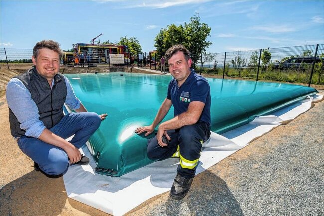Großrückerswalde: Eine PVC-Blase voller Wasser - Bürgermeister André Rösch und Gemeindewehrleiter Sebastian Hilbert (v. l.) verfolgten das Befüllen der 140.000 Liter fassenden Löschwasserzisterne. 