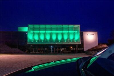 Grünes Leuchten in Plauen an Rathaus, Festhalle und Stadtbad: Das ist der Grund - Die Festhalle in Plauen leuchtete Samstagabend grün. Foto: Ellen Liebner
