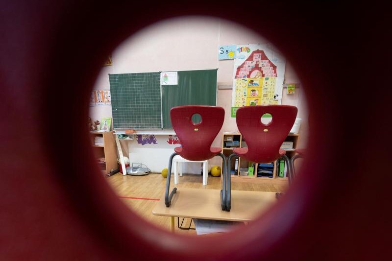            Stühle stehen in einem Klassenzimmer einer ersten Klasse.