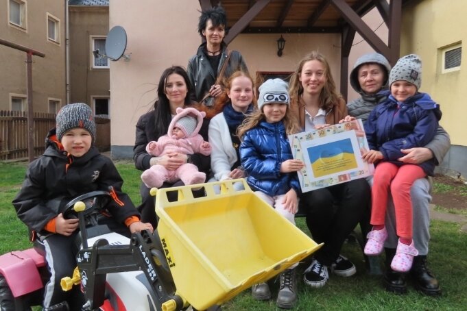 Nathalie Hilkman (Bildmitte, links) und ihre Klassenkameradin Chiara Engelhardt (Mitte rechts) bei der Übergabe der Erlöse des Kuchenbasars an ukrainische Kinder und deren Mütter. 